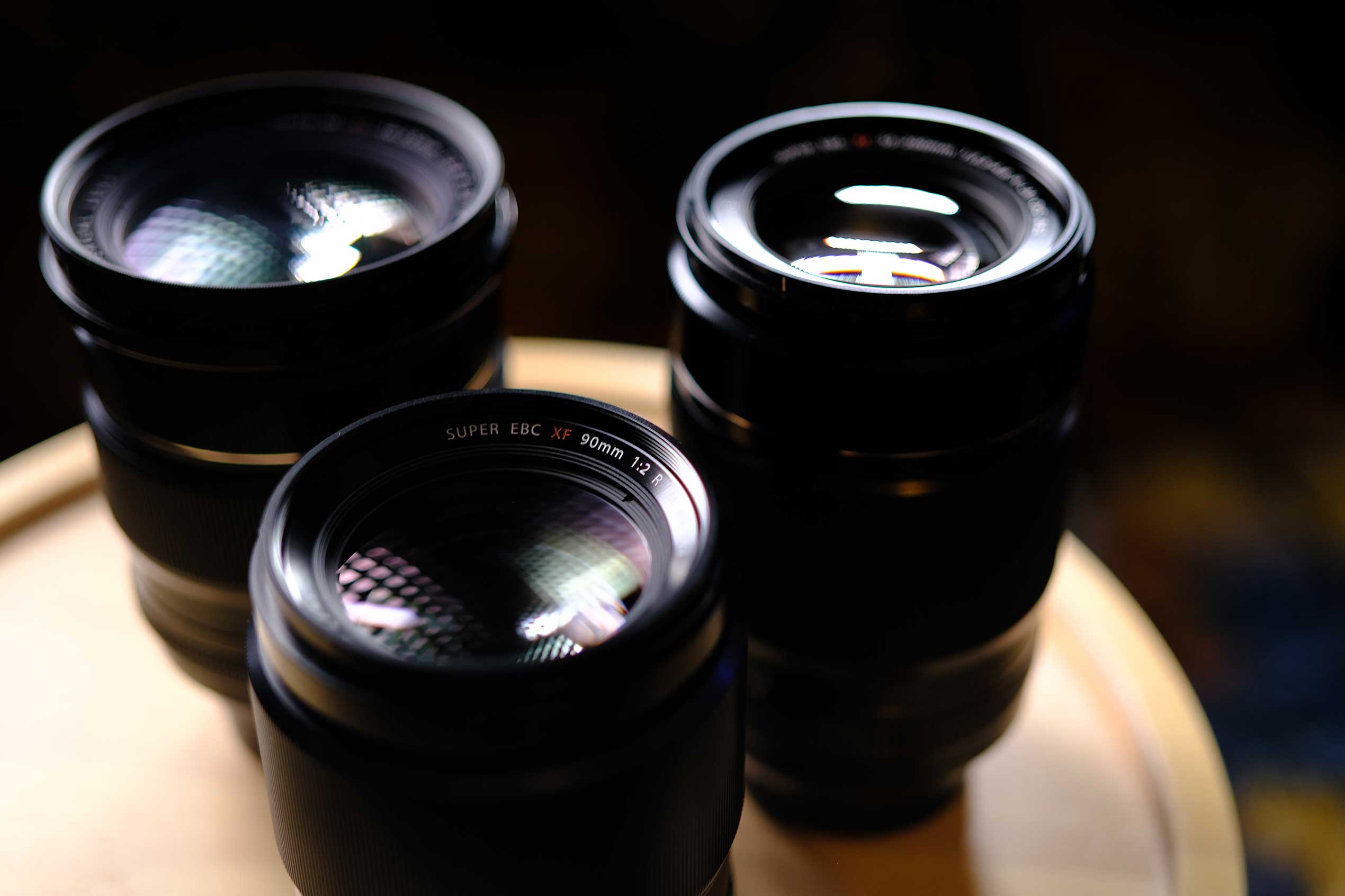 テーブル上に置かれた複数のFUJIFILM X-System交換レンズ。